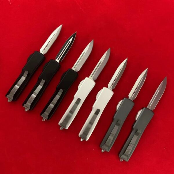 Back view of seven Microtech Mini UTX-85 OTF automatic knives with multiple blade styles