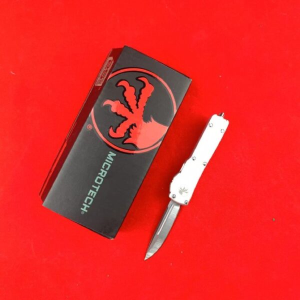 Microtech Mini UTX-85 OTF automatic knife with white handle and single-edge blade