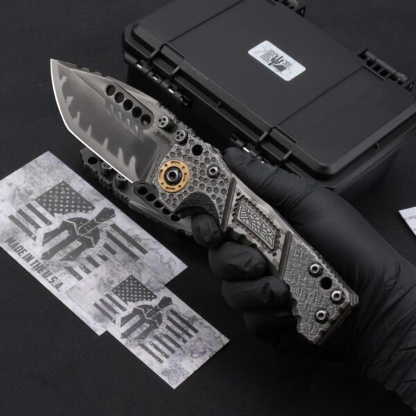 Handheld display of Miller Bros T1 Tactical Folder showing labyrinth pattern handle design